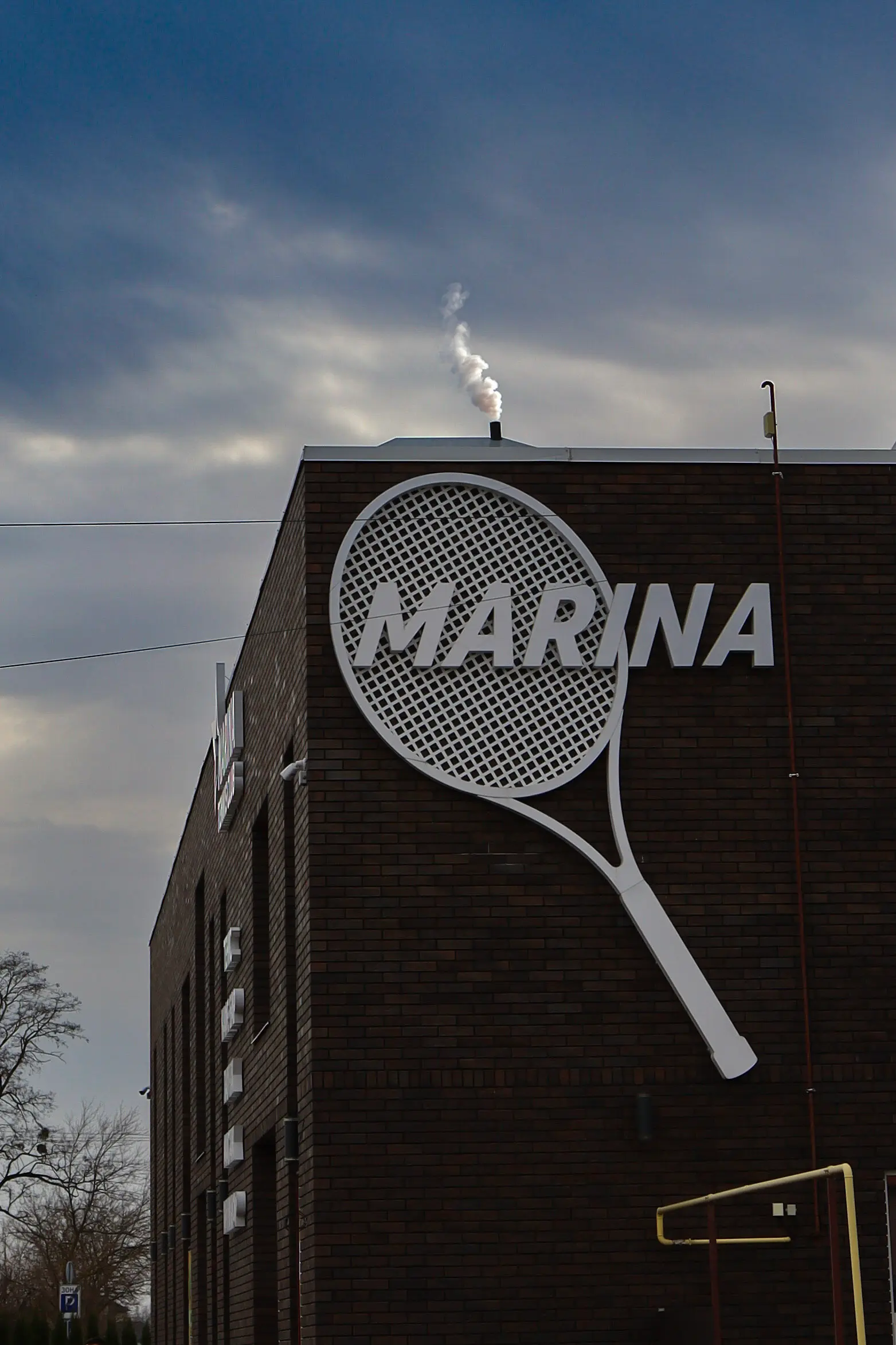 Фасад сучасного тенісного клубу Marina з вивіскою та енергоефективними технологіями